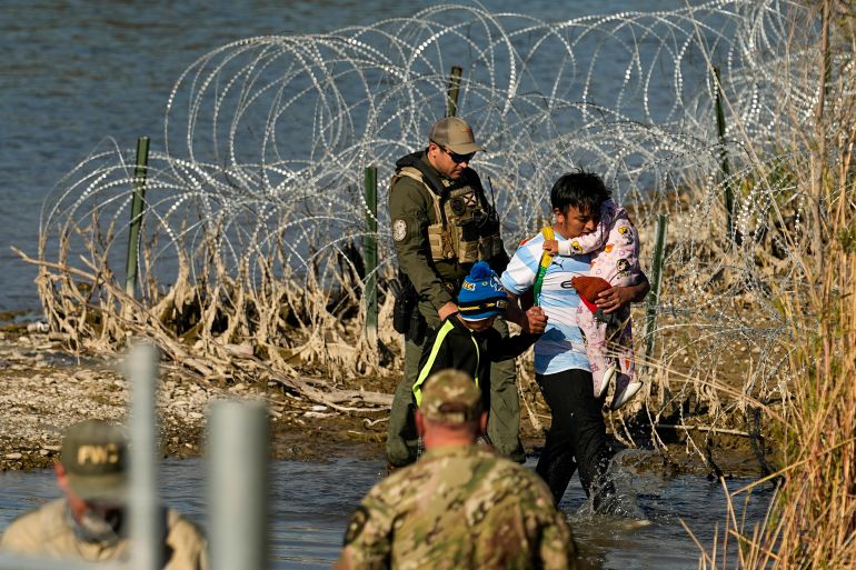 Migrants are taken into custody by officials at the Texas-Mexico border, Wednesday, Jan. 3