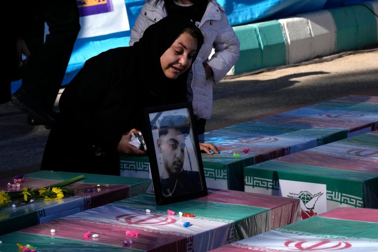 Uma mulher chora pelo caixão coberto com uma bandeira de seu filho, que foi morto na explosão de uma bomba na quarta-feira