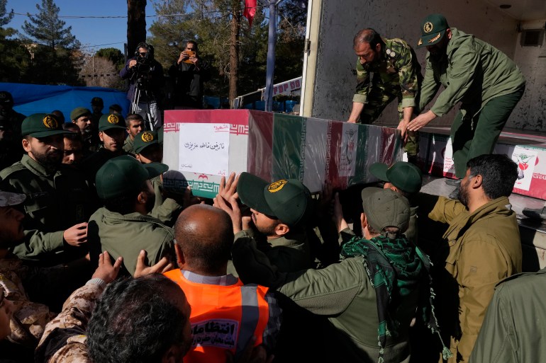 Revolutionary Guard members carry the Iranian flag-draped coffin of Nazanin Fatemeh Azizi