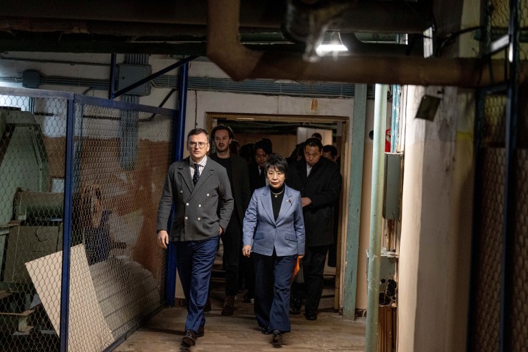 Ukraine's Foreign Minister Dmytro Kuleba guides Japan's Foreign Minister Yoko Kamikawa through an underground corridor. There are large pipes above them.