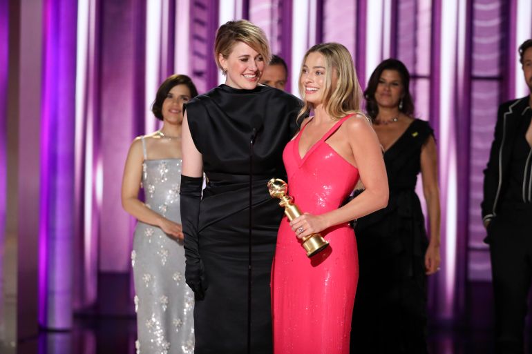 co-director Greta Gerwig, left, and actor Margot Robbie accepting the award for best cinematic and box office achievement for the film "Barbie"