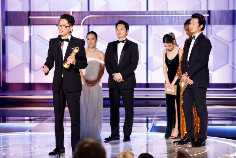 creator Lee Sung Jin, left, with actors Ali Wong, from second left and Steven Yeun as he accepts the award for best limited series for "Beef" during the 81st Annual Golden Globe Awards 