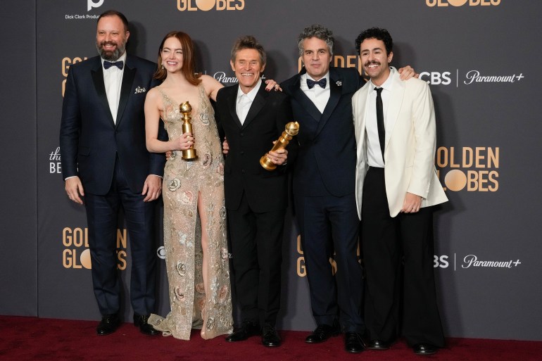 Yorgos Lanthimos, from left, Emma Stone, Willem Dafoe, Mark Ruffalo, and Ramy Youssef pose with the award for best motion picture, musical or comedy for "Poor Things" in the press room at the 81st Golden Globe Awards.