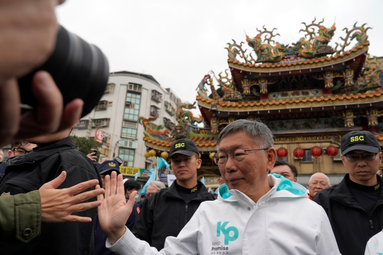 Ko Wen-je greeting supporters as he visits a temple. The temple is behind him.
