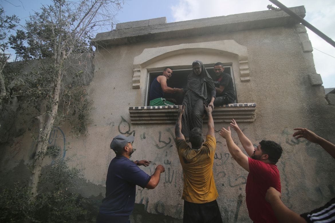 Palestinians evacuate a building hit in the Israeli bombardment of the Gaza Strip in Rafah