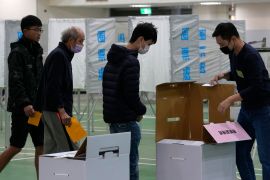 Voters inside a polling station. There are booths where they mark the ballot and the boxes outside