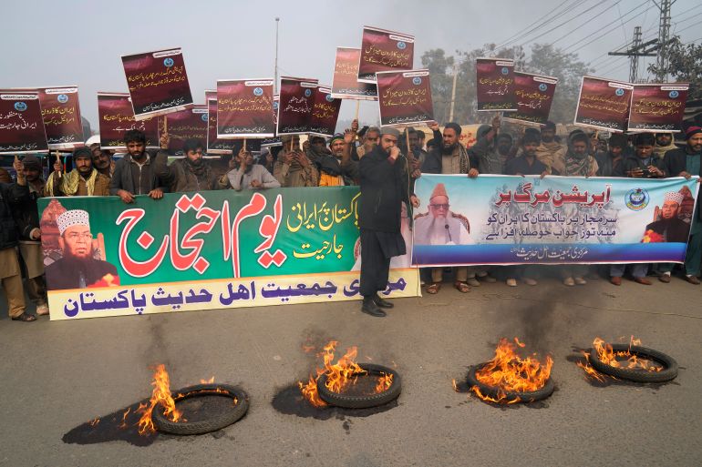Supporters of a religious group 'Markazi Jamiyat Ahle Hadith Pakistan' burn tires and hold a demonstration to condemn Iran strike in the Pakistani border area, in Lahore, Pakistan, Friday, Jan. 19, 2024. The unprecedented attacks by both Pakistan and Iran on either side of their border appeared to target Baluch militant groups with similar separatist goals. The countries accuse each other of providing a haven to the groups in their respective territories. The banner in Urdu language on left, reads "Protest against Irani aggression". (AP Photo/K.M. Chaudary)