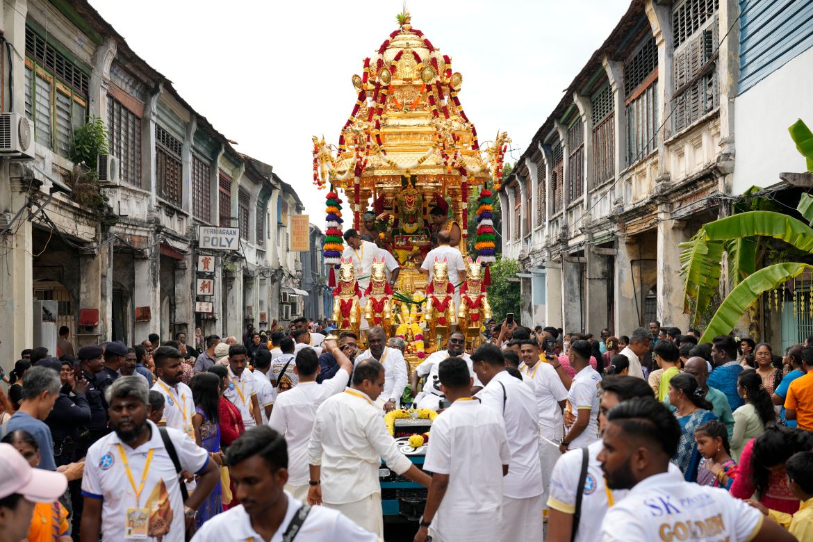 The gold chariot bearing the idol of Hindu god Lord Murugan is paraded on a street in Penang during Thaipusam