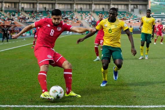 Tunisia's Hamza Rafia, left, challenges for the ball with South Africa's Aubrey Modiba during the African Cup of Nations Group E soccer match between South Africa and Tunisia, in Korhogo, Ivory Coast, Wednesday, Jan. 24, 2024. (AP Photo/Themba Hadebe)