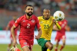 Tunisia's Ali Abdi, left, views for the ball with South Africa's Thapelo Morena