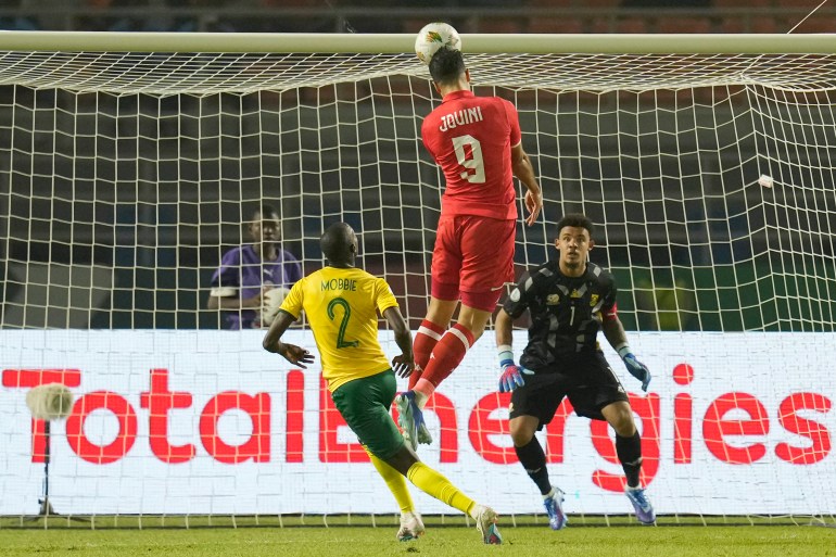 Tunisia's Haythem Jouini, top, jumps for the ball as he attempts a goal