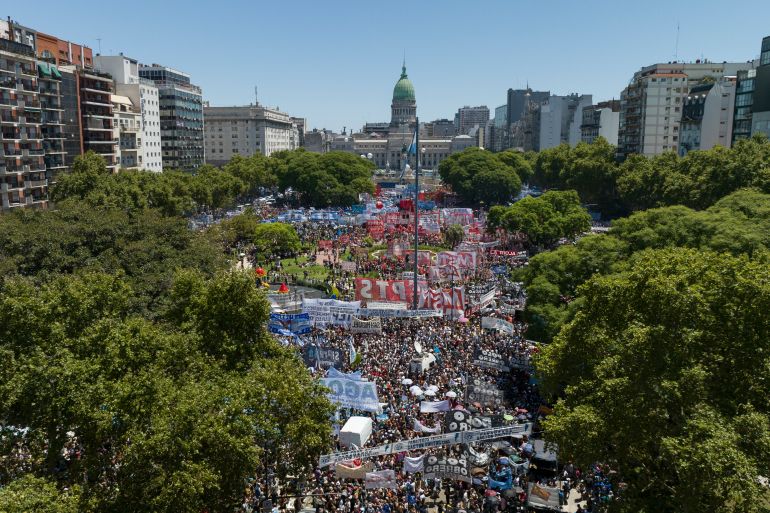 An aerial view of the plaza in front of Argentina's domed congress building. Lined by trees, the plaza is packed with protesters.