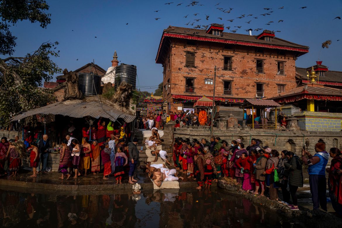 Hindu devotees perform rituals by the Hanumante river during Madhav Narayan festival in Bhaktapur, Nepal, Thursday, Jan. 25