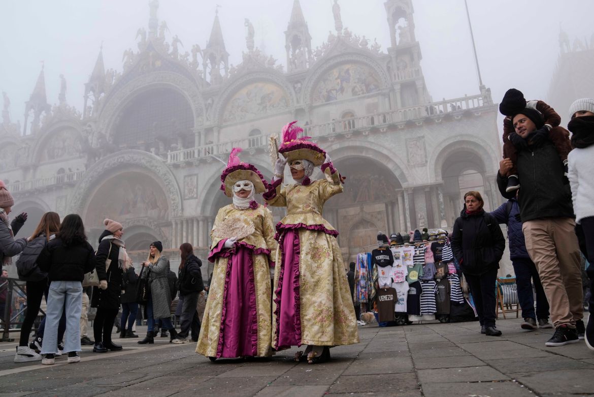 Two women in traditional Venetian dress walk, during the open street show of the Carnival, in Venice, Italy, Saturday, Jan. 27,