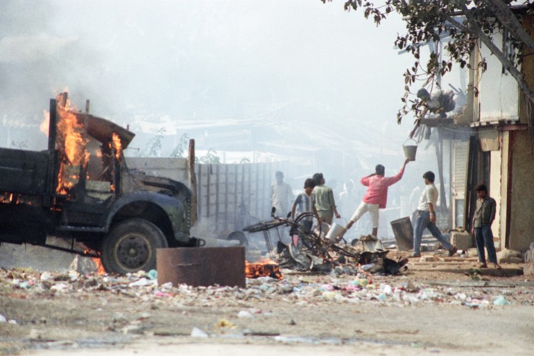 Anwohner reichen Wassereimer weiter, um Brände nach Unruhen in Bombay am Mittwoch, 13. Januar 1993, zu löschen. Am Mittwoch wurden vier Menschen bei hinduistisch-muslimischer Gewalt erstochen, die laut Nachrichtenberichten in acht Tagen der Unruhen fast 500 Menschen das Leben gekostet hat sagte.  (AP Photo/Ajit Kumar)