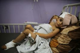 Kenzi al Madhoun, a four-year-old who was wounded in Israeli bombardment, lies at Al Aqsa Hospital
