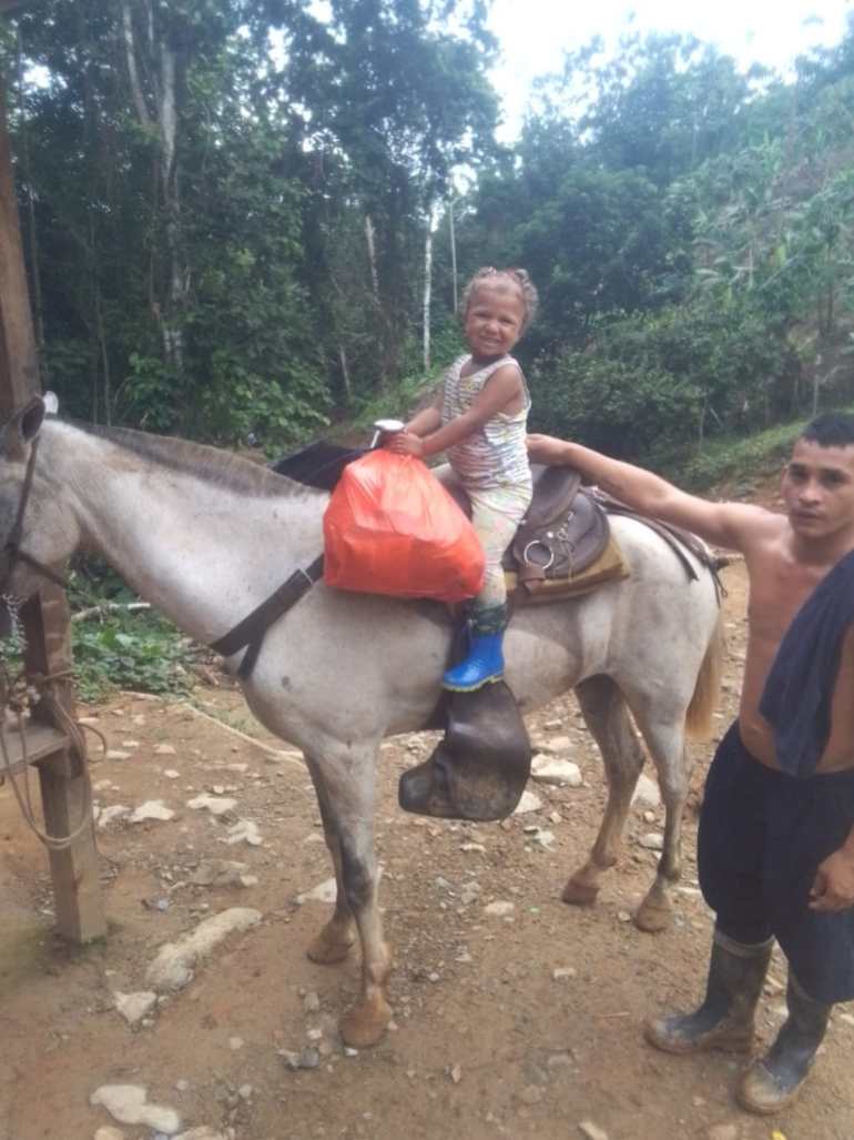 Emiliannys, a little girl, poses atop a horse in the tropical jungles of the Darien Gap.