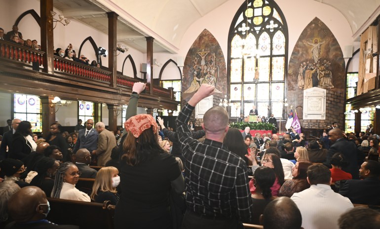people stand up while others are seated in a church