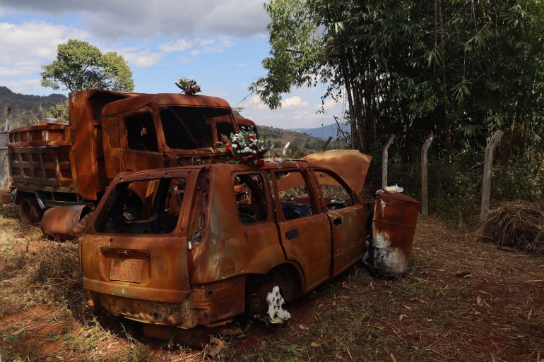 Flowers left on the rusting vehicles where the Myanmar military killed dozens on 24 Dec 2023.