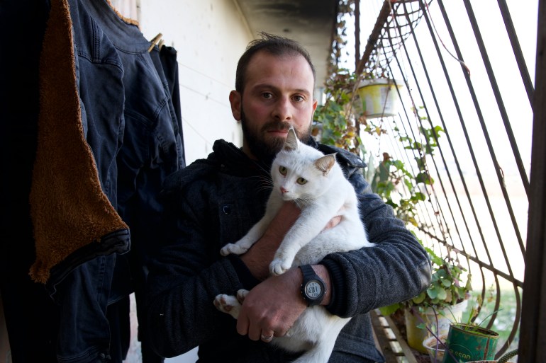 Muhammad Halabi holds his cat Farah