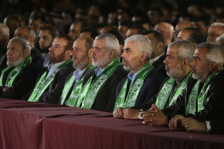 Yahya Sinwar (3º à direita), o novo líder do movimento islâmico Hamas na Faixa de Gaza e o líder político sênior Ismail Haniyeh (4º à direita) sentam-se entre outros funcionários do Hamas durante um memorial para Mazen Faqha, um líder do movimento islâmico que foi baleado morto por homens armados desconhecidos na Faixa de Gaza, em 27 de março de 2017, na Cidade de Gaza.  Autoridades do Hamas disseram que o assassinato traz as características do serviço de inteligência de Israel, o Mossad, mas Israel não comentou o tiroteio.