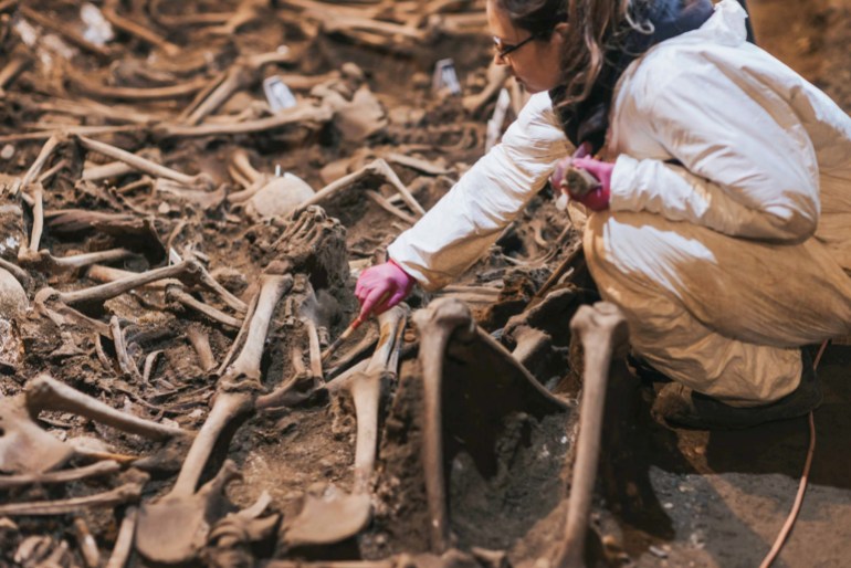 A forensic expert excavates a mass grave in Georgia