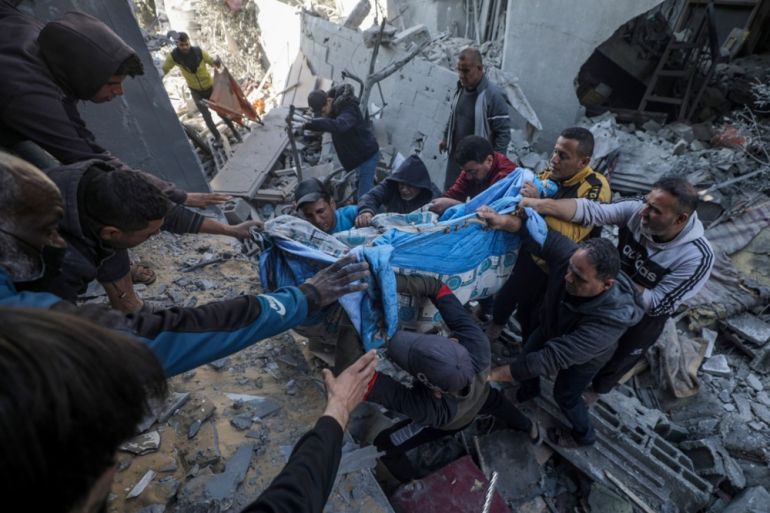 epa11171819 Palestinians recover a body from the rubble of a destroyed house following Israeli air strikes, in Deir Al Balah, central Gaza Strip, 22 February 2024. More than 29,300 Palestinians and over 1,300 Israelis have been killed, according to the Palestinian Health Ministry and the Israel Defense Forces (IDF), since Hamas militants launched an attack against Israel from the Gaza Strip on 07 October 2023, and the Israeli operations in Gaza and the West Bank which followed it. EPA-EFE/MOHAMMED SABER