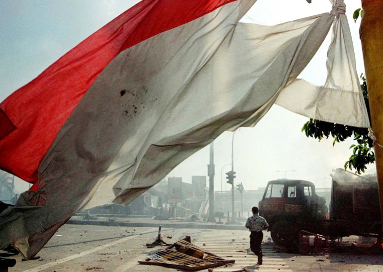 A tattered Indonesian flag and a burnt out car near Trisakti in May 1998
