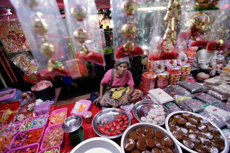 A woman sells Chinese traditional snacks and gifts ahead of Chinese Lunar New Year at Chinatown in Yangon February 7, 2013.