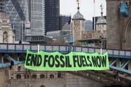 Climate change activists hang a sign on Tower Bridge during a demonstration against the climate crisis, in central London, Britain, April 8, 2022. REUTERS/Tom Nicholson