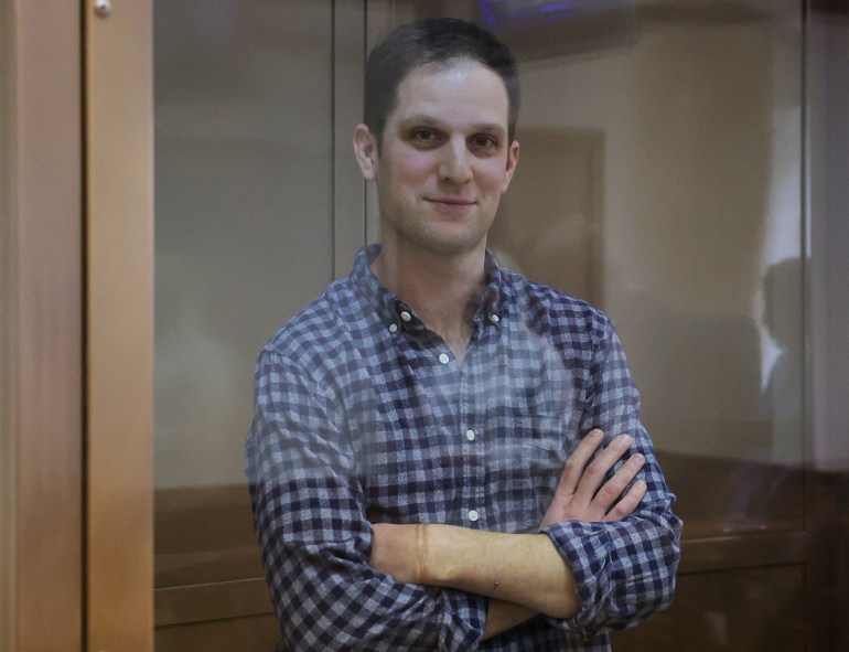 O repórter do Wall Street Journal Evan Gershkovich, que foi detido em março durante uma viagem de reportagem e acusado de espionagem, está atrás de uma parede de vidro de um recinto para réus