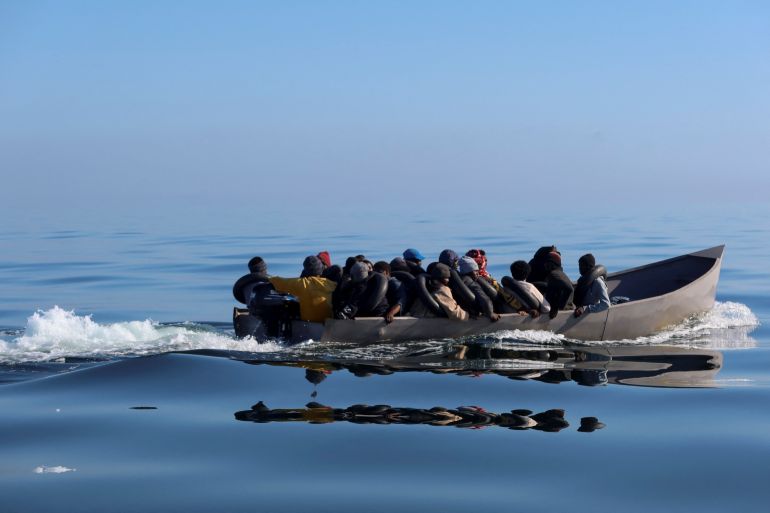 Migrants navigate on a metal boat as they are spotted by Tunisian coast guards at sea during their attempt to cross to Italy,