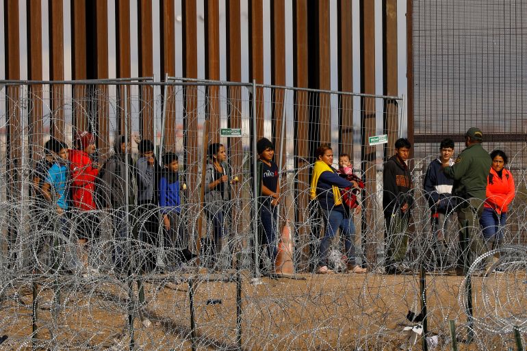 Migrants seeking asylum in the US gather near the fence on the US-Mexico border, as they wait to be processed by US Border Patrol in El Paso, Texas, as seen from Ciudad Juarez, Mexico January 23, 2024