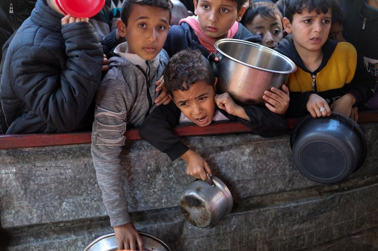 Children carrying pots to receive food