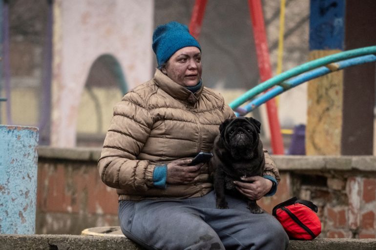 A local resident with her dog sits near her residential building damaged during a Russian missile strike in Kyiv, Ukraine February 7, 2024. REUTERS/Danylo Antoniuk TPX IMAGES OF THE DAY