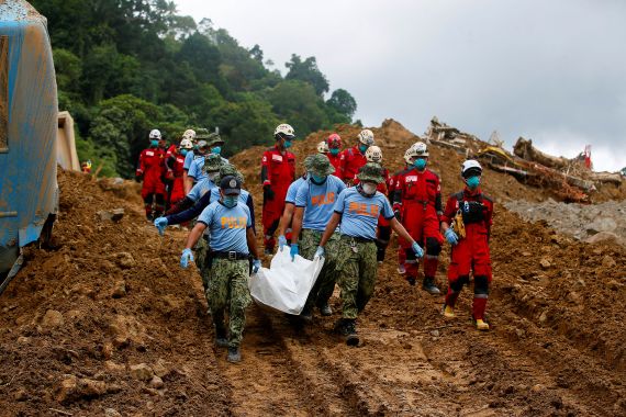 Police officers carry a body bag as search and rescue operations continue in the landslide-hit village of Masara, Maco, Davao de Oro, Philippines, February 8, 2024. REUTERS/Mark Navales NO RESALES. NO ARCHIVES