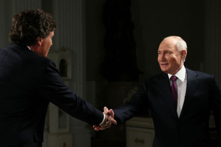 Russian President Vladimir Putin shakes hands with U.S. television host Tucker Carlson during an interview in Moscow, Russia February 6, 2024. Sputnik/Gavriil Grigorov/Kremlin via REUTERS ATTENTION EDITORS - THIS IMAGE WAS PROVIDED BY A THIRD PARTY.