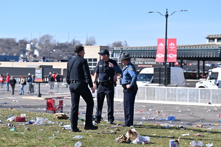 Three police officers stand in an empty field surrounded by empty Solo cups after gunfire dispersed a Super Bowl celebration.