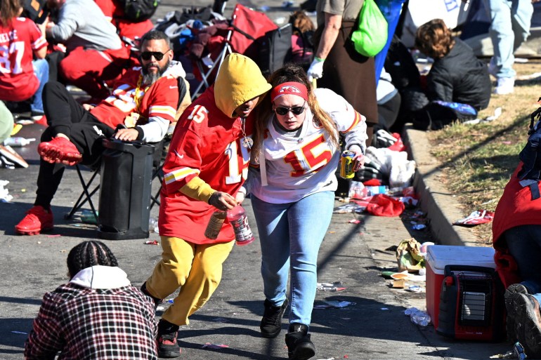 Two Kansas City Chiefs fans run for safety as gunfire breaks out during a victory celebration.