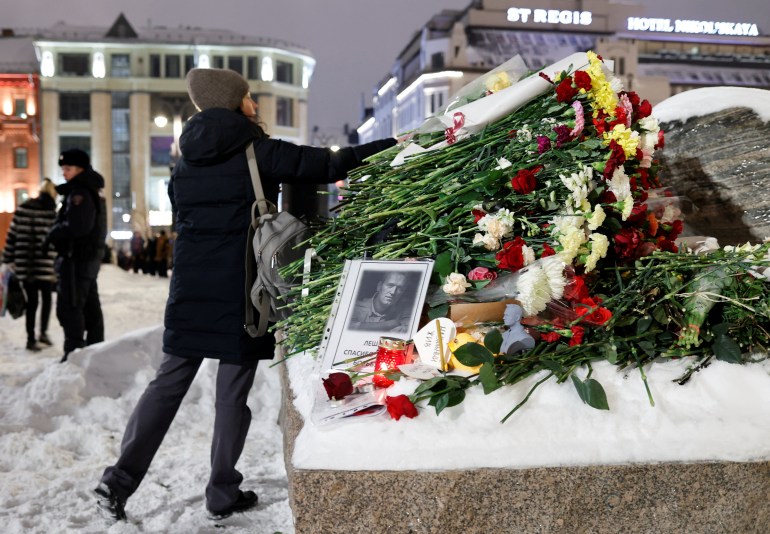 A woman lays flowers at the monument to the victims of political repressions following the death of Russian opposition leader Alexei Navalny, in Moscow, Russia February 16, 2024. REUTERS/Stringer
