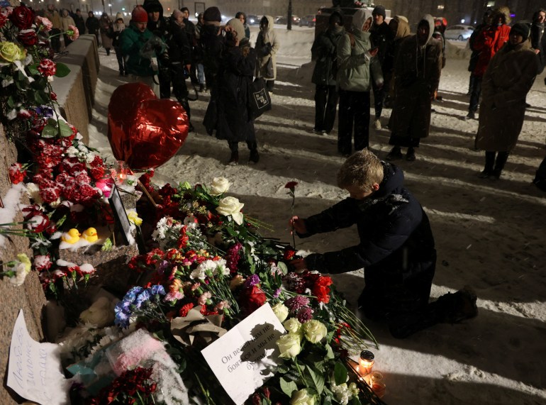 A man places a flower at the monument to the victims of political repressions following the death of Russian opposition leader Alexei Navalny in Saint Petersburg, Russia February 16, 2024. REUTERS/Stringer