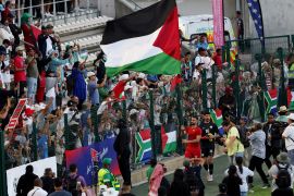 Palestinian footballer Bashar al-Shobaki and fans display flags after a friendly match in Cape Town, South Africa [Esa Alexander/Reuters]