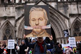 A supporter of WikiLeaks founder Julian Assange stands outside the High Court on the day Assange appeals against his extradition to the United States, in London [Isabel Infantes/Reuters]