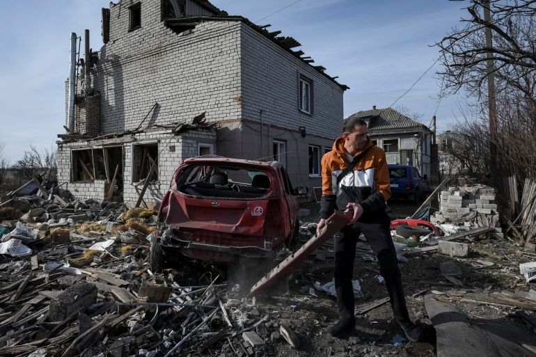 A local resident prepares a damaged car to be towed, near a residential building damaged during a Russian drone strike, amid Russia's attack on Ukraine, in Dnipro, Ukraine February 26, 2024. REUTERS/Mykola Synelnykov