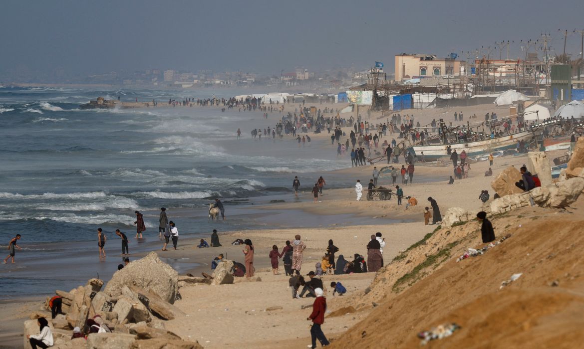 Palestinians gather on a beach in the hope of getting aid air-dropped