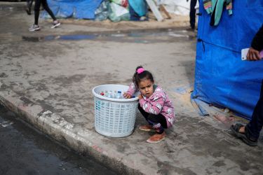 A child looks on, as displaced Palestinians, who fled their houses due to Israeli strikes, shelter at a tent camp, amid the ongoing conflict between Israel and Hamas