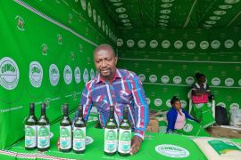 A member of the Twitule cooperative sells bottles of banana wine at a trade fair in Blantyre, Malawi [Courtesy COMSIP Cooperative Union]