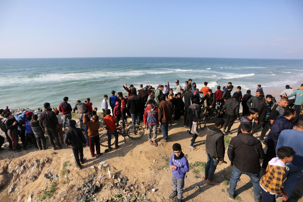 Palestinians wait for humanitarian aid airdrop at the beach in Deir al Balah