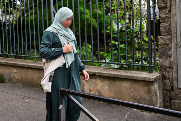 Eine Frau, die eine Abaya trägt, geht durch die Straßen von Paris