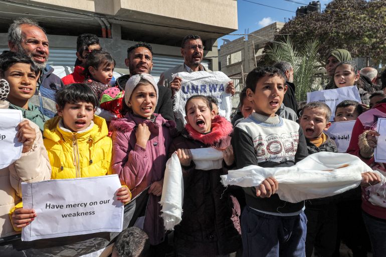 Homens e crianças palestinos se reúnem para uma manifestação em Rafah, no sul da Faixa de Gaza, em 30 de janeiro de 2024, pedindo apoio internacional contínuo à Agência das Nações Unidas de Assistência e Obras para Refugiados Palestinos no Oriente Próximo (UNRWA) em meio ao conflito em curso entre Israel e o grupo militante palestino Hamas.  - Pelo menos 12 países - com os principais doadores, os Estados Unidos e a Alemanha, a que se juntaram a Nova Zelândia em 30 de Janeiro - suspenderam o seu financiamento à UNRWA devido às alegações israelitas de que alguns dos seus funcionários estavam envolvidos no ataque de 7 de Outubro.  (Foto da AFP)